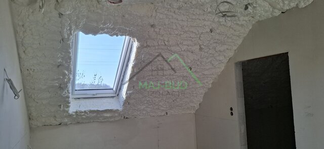 Skos z oknem dachowym po ociepleniu, obok wejście do pomieszczenia